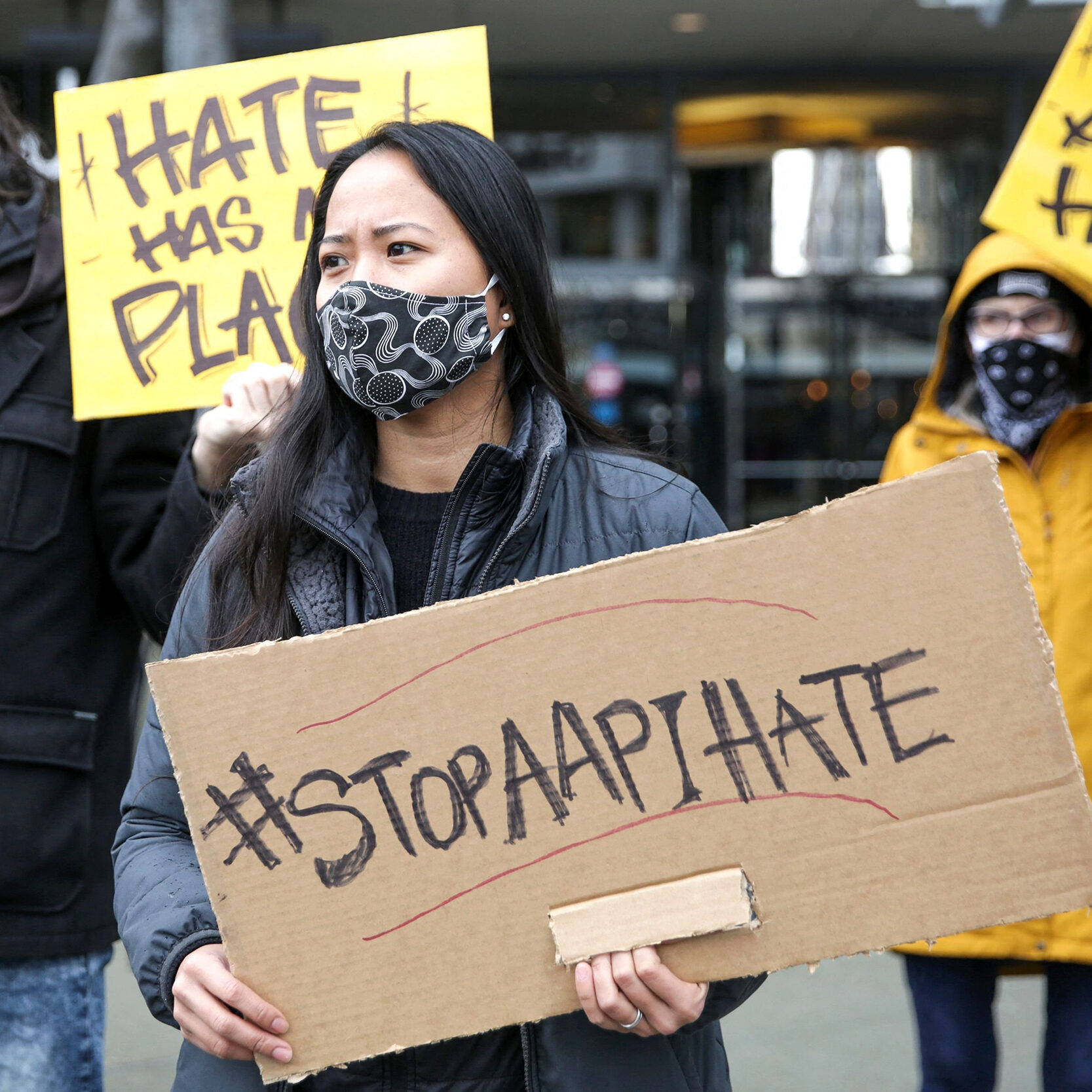 Trish Villanueva (C) of Seattle holds a sign with the hashtag "stop AAPI hate" during the We Are Not Silent rally organized by the Asian American Pacific Islander (AAPI) Coalition Against Hate and Bias in Bellevue, Washington on March 18, 2021. - The shooting rampage in Atlanta by a 21-year-old white man that left six women of Asian origin dead has laid bare the fears of an Asian-American community on edge over a spike in hate crimes because of the coronavirus pandemic. (Photo by Jason Redmond / AFP) (Photo by JASON REDMOND/AFP via Getty Images)